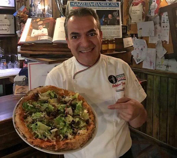 Salvatore Gatta con pizza nel suo locale