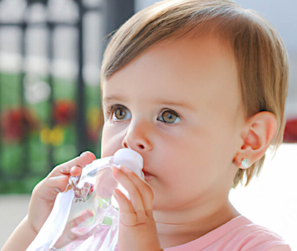 Bambini e acqua minerale bambina che beve dalla bottiglia